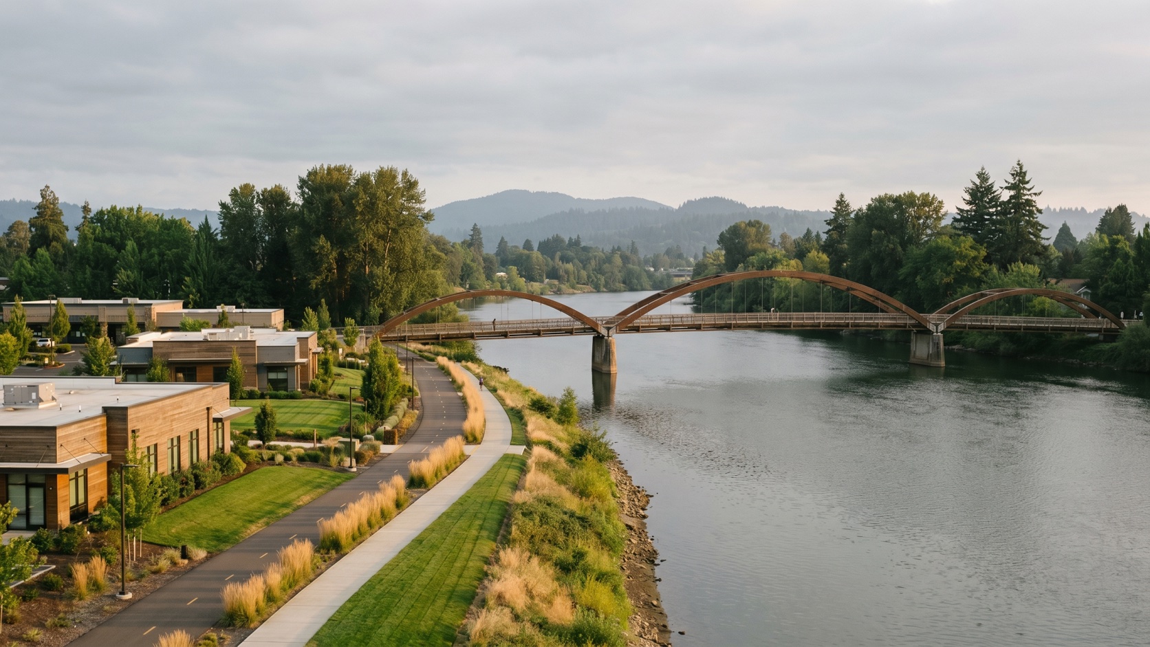 Willamette River and riverfront path with a pedestrian bridge near downtown Eugene at golden hour